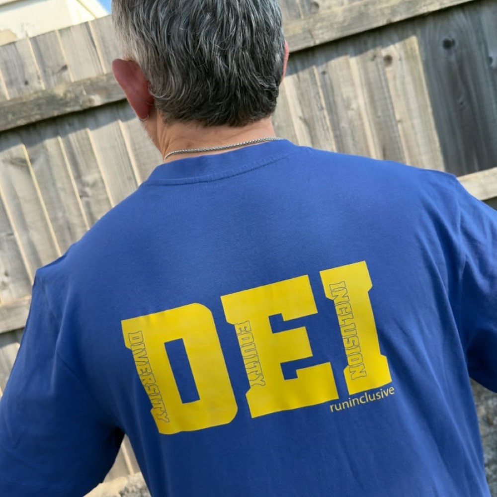 Huseyin wearing the cotton DEI tee with the word cut outs on the back